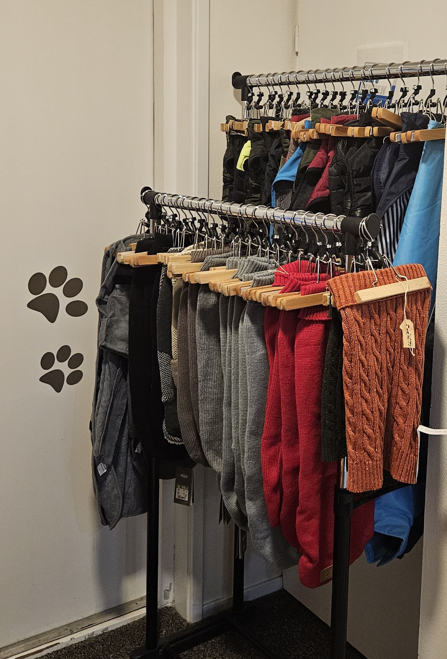 Een rek met hondenjasjes in allerlei kleuren